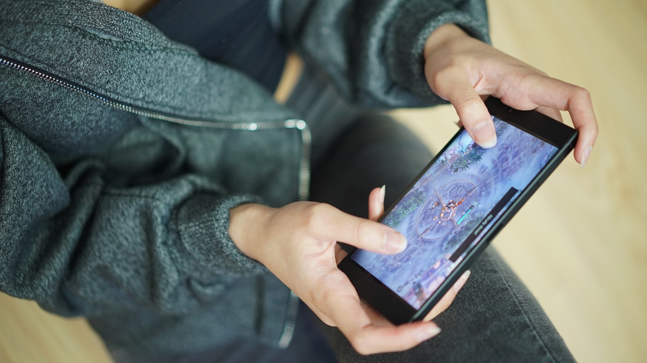 Person interacting with a mobile gaming setup at a technology showcase